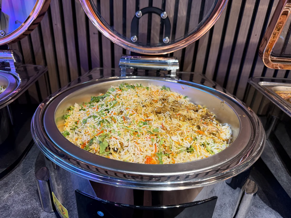 Chicken biryani served in a round buffet chafing dish