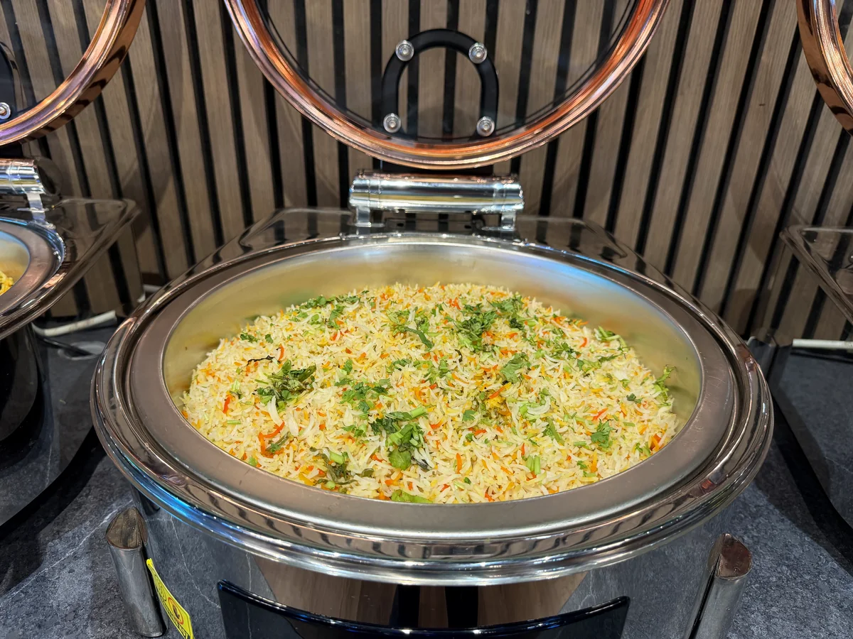 Vegetable pulao served in a round buffet chafing dish